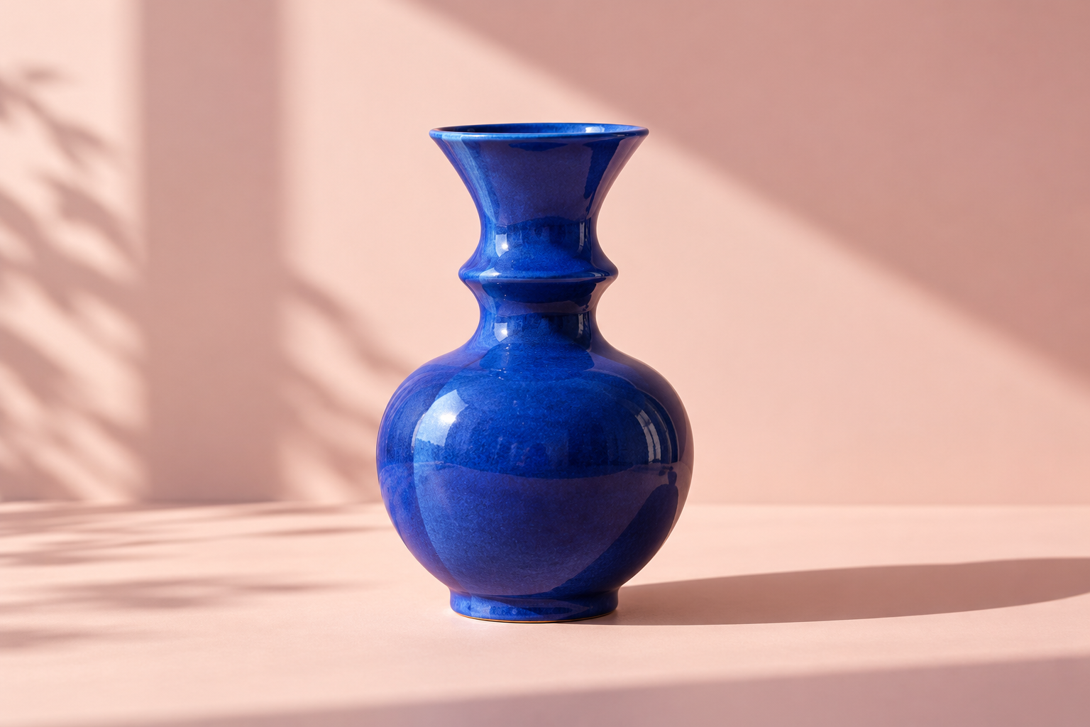 Jarrón azul sobre un fondo rosa suave